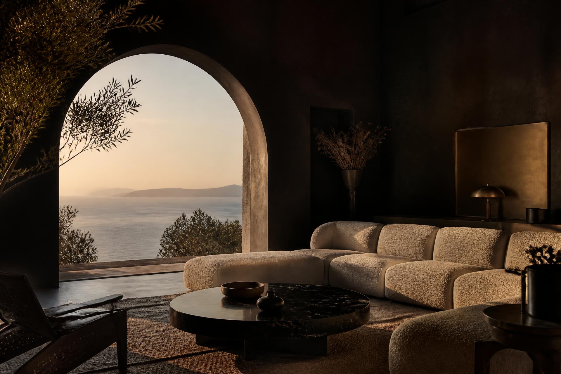 A dark plaster living room opening onto the sea through a stone arch